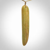 Raukaraka Pounamu drop pendant. Hand carved by Rhys Hall for NZ Pacific. Handmade jewellery for sale online. The cord is a 3-braid plait in tan and has a loop and pebble toggle closure. Drop necklace for men and women. Large drop necklace hand made from New Zealand Jade.